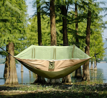 Hammock hanging in between trees with a mosquito net set up